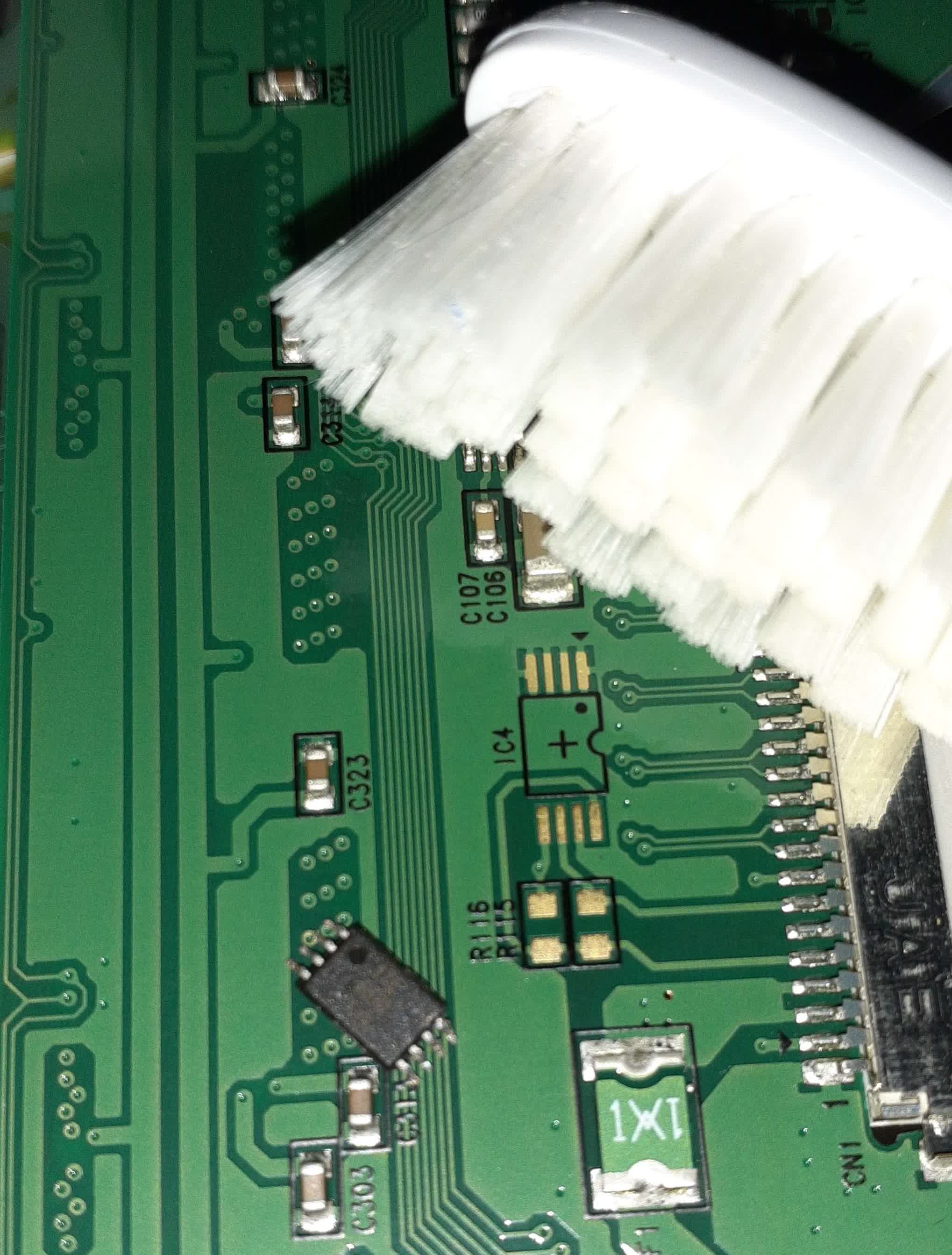 The EDID EEPROM chip on a circuit board next to the PCB footprint for it. A toothbrush is also in frame.
