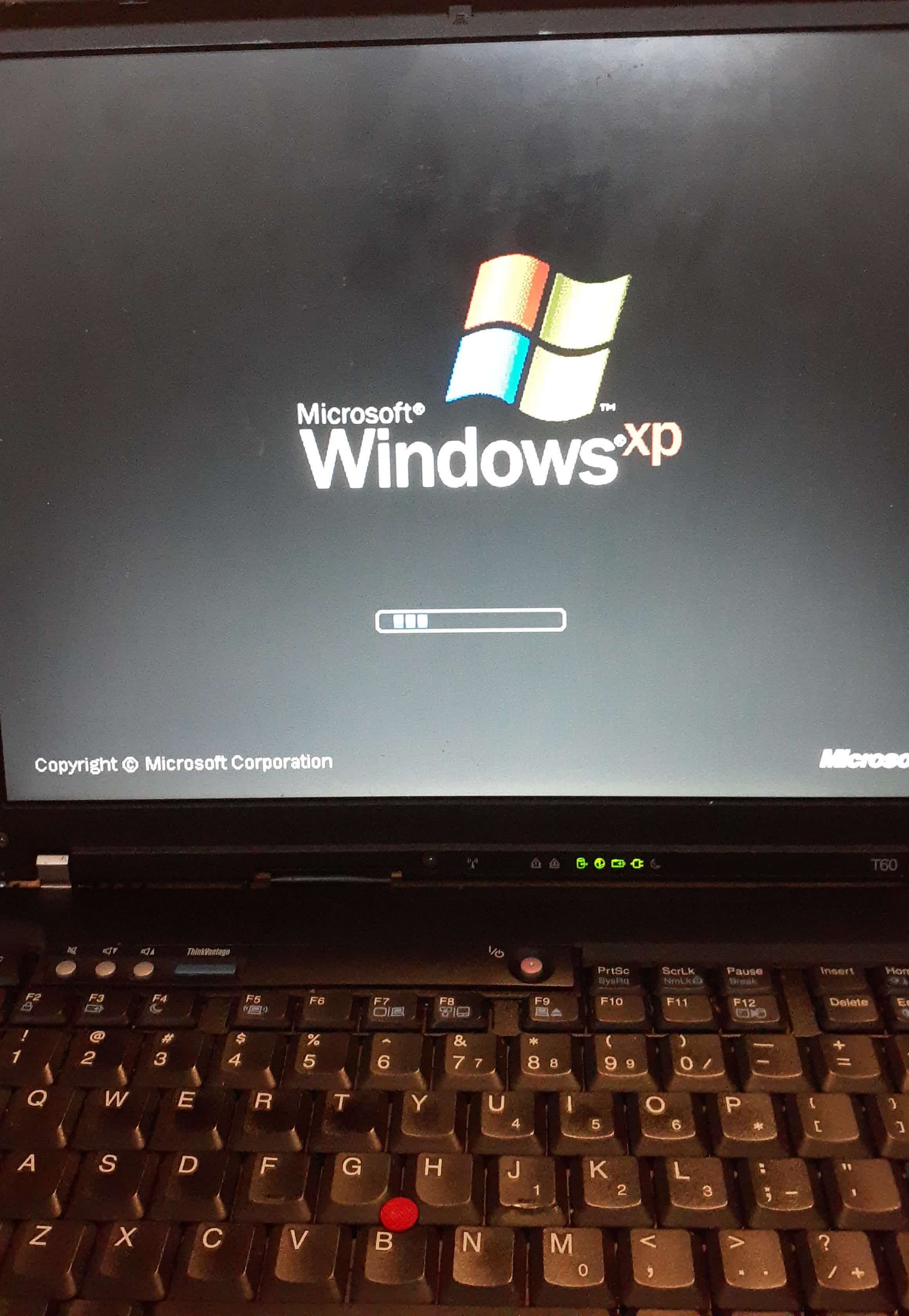The ThinkPad screen shows the Windows XP loading screen, with no issues.